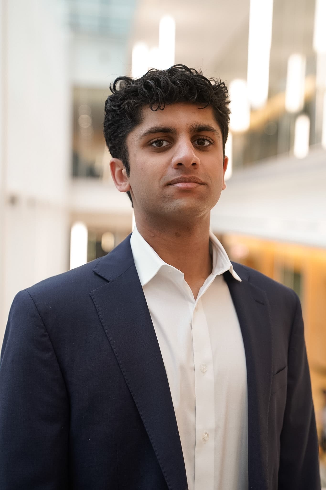 Editorial portrait of Muhammad Rafiq against a warm neutral background